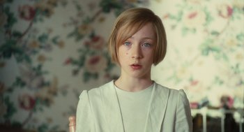 Movie still from “Atonement” (2007), directed by Joe Wright – A girl with short blonde hair wearing a white shirt; Close Up shot, High angle