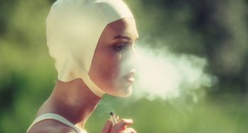 Movie still from “Atonement” (2007), directed by Joe Wright – A woman in a white hat is smoking a cigarette; Close Up shot, Over the shoulder angle