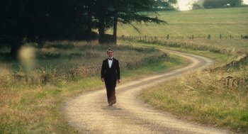 Movie still from “Atonement” (2007), directed by Joe Wright – A man in a tuxedo walking down a dirt road; Extreme Wide shot, High angle