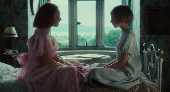 Movie still from “Atonement” (2007), directed by Joe Wright – Two young girls sitting in front of a window; Medium shot, Over the shoulder angle
