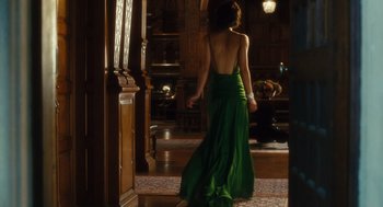 Movie still from “Atonement” (2007), directed by Joe Wright – A woman in a green dress standing in front of a mirror; Wide shot, Over the shoulder angle