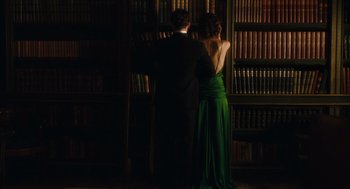 Movie still from “Atonement” (2007), directed by Joe Wright – A man and a woman standing in front of a book shelf; Medium shot, Low angle