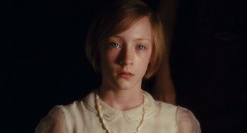 Movie still from “Atonement” (2007), directed by Joe Wright – A young girl wearing a white shirt and a white necklace; Close Up shot, High angle