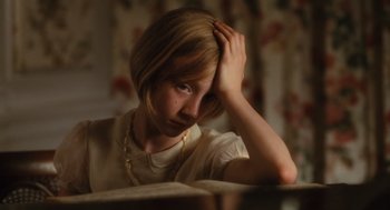 Movie still from “Atonement” (2007), directed by Joe Wright – A woman sitting at a table with her head resting on her hand; Close Up shot, High angle