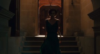 Movie still from “Atonement” (2007), directed by Joe Wright – A woman in a green dress walking down a set of stairs; Wide shot, Low angle