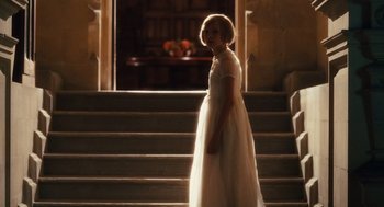 Movie still from “Atonement” (2007), directed by Joe Wright – A girl in a white dress standing in front of a staircase; Wide shot, Over the shoulder angle