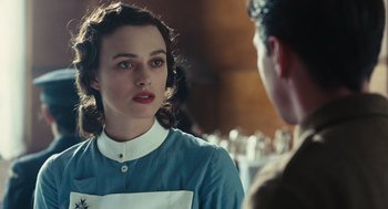 Movie still from “Atonement” (2007), directed by Joe Wright – A woman in a blue dress is talking to a man in a brown suit; Close Up shot, Over the shoulder angle