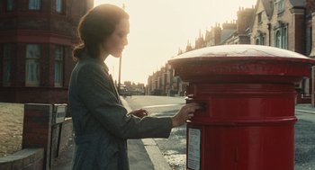 Movie still from “Atonement” (2007), directed by Joe Wright – A woman is putting money into a red mailbox; Close Up shot, Low angle