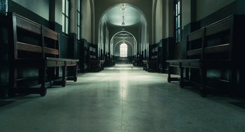 Movie still from “Atonement” (2007), directed by Joe Wright – An empty church hallway with benches and windows; Extreme Wide shot, High angle