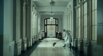 Movie still from “Atonement” (2007), directed by Joe Wright – A group of men sweeping a floor in a large room; Wide shot, Low angle
