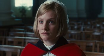 Movie still from “Atonement” (2007), directed by Joe Wright – A young woman wearing a red and white cape; Close Up shot, Low angle