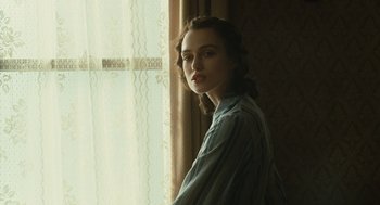 Movie still from “Atonement” (2007), directed by Joe Wright – A woman standing in front of a window with curtains; Close Up shot, Over the shoulder angle