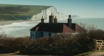 Movie still from “Atonement” (2007), directed by Joe Wright – A blue house with two chimneys on top of it; Extreme Wide shot, Low angle