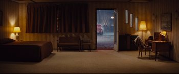 Movie still from “Bad Times at the El Royale” (2018), directed by Drew Goddard – A room that has a couch and chair in it; Wide shot, High angle