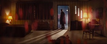 Movie still from “Bad Times at the El Royale” (2018), directed by Drew Goddard – A man standing in a room next to a dead body; Wide shot, Low angle