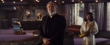 Movie still from “Bad Times at the El Royale” (2018), directed by Drew Goddard – An older man with a beard and a black suit; Medium shot, Low angle