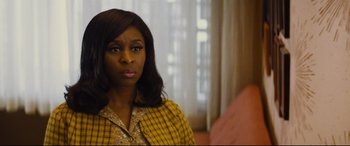 Movie still from “Bad Times at the El Royale” (2018), directed by Drew Goddard – A woman in a yellow and black jacket looking at the camera; Close Up shot, Over the shoulder angle