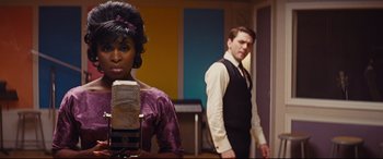 Movie still from “Bad Times at the El Royale” (2018), directed by Drew Goddard – A man and a woman standing next to each other in a room; Medium shot, Over the shoulder angle