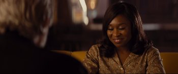 Movie still from “Bad Times at the El Royale” (2018), directed by Drew Goddard – A woman sitting on top of a yellow couch; Close Up shot, Over the shoulder angle