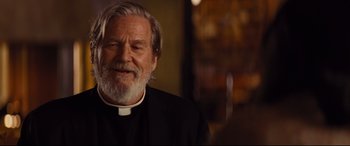 Movie still from “Bad Times at the El Royale” (2018), directed by Drew Goddard – An older man with a long white beard and wearing a black clerical outfit; Close Up shot, Over the shoulder angle