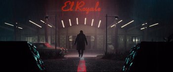 Movie still from “Bad Times at the El Royale” (2018), directed by Drew Goddard – A man walking down a street in front of a building; Wide shot, Low angle