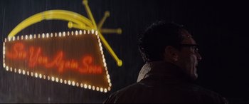 Movie still from “Bad Times at the El Royale” (2018), directed by Drew Goddard – A man standing in front of a neon sign at night; Close Up shot, Low angle