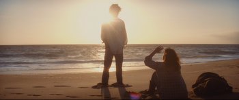 Movie still from “Bad Times at the El Royale” (2018), directed by Drew Goddard – Two people on the beach watching the sun go down; Wide shot, Over the shoulder angle