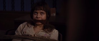 Movie still from “Bad Times at the El Royale” (2018), directed by Drew Goddard – A young girl with her mouth taped shut sitting in a chair; Close Up shot, Over the shoulder angle