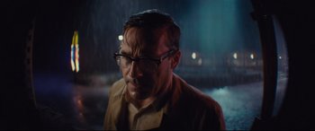 Movie still from “Bad Times at the El Royale” (2018), directed by Drew Goddard – A man wearing glasses standing in the rain at night; Close Up shot, Over the shoulder angle