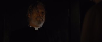 Movie still from “Bad Times at the El Royale” (2018), directed by Drew Goddard – A man wearing a priest's outfit looking into the distance; Close Up shot, Low angle