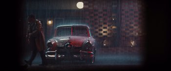 Movie still from “Bad Times at the El Royale” (2018), directed by Drew Goddard – An old car is parked in the rain outside; Wide shot, Low angle