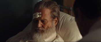 Movie still from “Bad Times at the El Royale” (2018), directed by Drew Goddard – An older man with a bandage on his head; Close Up shot, Low angle