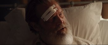 Movie still from “Bad Times at the El Royale” (2018), directed by Drew Goddard – An older man with a bandage on his forehead; Close Up shot, Over the shoulder angle