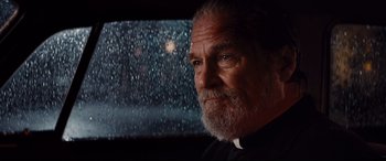 Movie still from “Bad Times at the El Royale” (2018), directed by Drew Goddard – An older man with a beard looking out of a car window; Close Up shot, Low angle