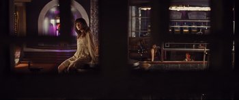 Movie still from “Bad Times at the El Royale” (2018), directed by Drew Goddard – A woman sitting on the ground in front of a window; Wide shot, Over the shoulder angle