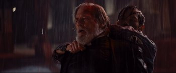 Movie still from “Bad Times at the El Royale” (2018), directed by Drew Goddard – An old man with a beard is getting his hair cut; Close Up shot, Over the shoulder angle