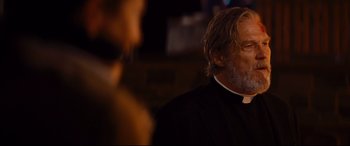 Movie still from “Bad Times at the El Royale” (2018), directed by Drew Goddard – A man in a priest's outfit looking at something; Close Up shot, Over the shoulder angle