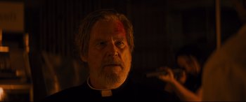 Movie still from “Bad Times at the El Royale” (2018), directed by Drew Goddard – An older man with a knife in his mouth; Close Up shot, Low angle