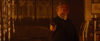 Movie still from “Bad Times at the El Royale” (2018), directed by Drew Goddard – An older man with a beard is holding a gun; Medium shot, Low angle