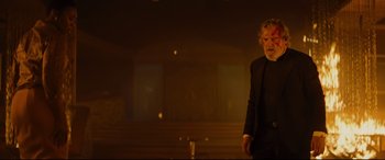 Movie still from “Bad Times at the El Royale” (2018), directed by Drew Goddard – A man standing in a dark room with a microphone in front of him; Medium shot, Low angle