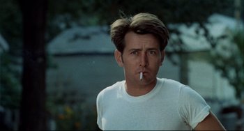 Movie still from “Badlands” (1973), directed by Terrence Malick – A young man smoking a cigarette while wearing a t - shirt; Close Up shot, Low angle