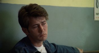 Movie still from “Badlands” (1973), directed by Terrence Malick – A man with a beard is sitting down; Close Up shot, Low angle