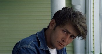 Movie still from “Badlands” (1973), directed by Terrence Malick – A person wearing a jean jacket; Close Up shot, Low angle