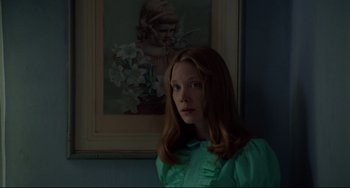 Movie still from “Badlands” (1973), directed by Terrence Malick – A woman in a green shirt in front of a painting; Close Up shot, Low angle
