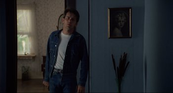 Movie still from “Badlands” (1973), directed by Terrence Malick – A man standing in front of a door in a room; Medium shot, Over the shoulder angle