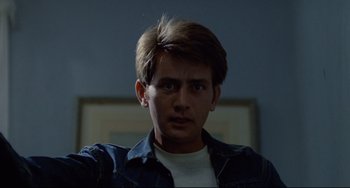 Movie still from “Badlands” (1973), directed by Terrence Malick – A young man in a white t - shirt and a blue jacket; Close Up shot, Low angle