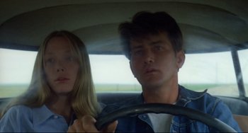 Movie still from “Badlands” (1973), directed by Terrence Malick – A man and a woman sitting in the back of a car; Close Up shot, Low angle