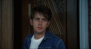 Movie still from “Badlands” (1973), directed by Terrence Malick – A young man in a jean jacket looking at the camera; Close Up shot, Over the shoulder angle