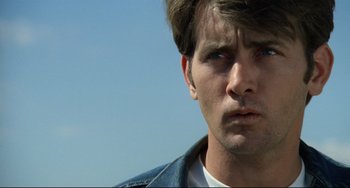 Movie still from “Badlands” (1973), directed by Terrence Malick – A person wearing a jean jacket; Close Up shot, Low angle