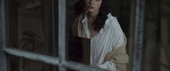 Movie still from “Becoming Jane” (2007), directed by Julian Jarrold – A woman in a white shirt looking out of a window; Close Up shot, High angle